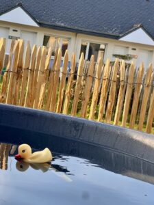 Bain nordique extérieur avec canard flottant devant les chambres de l’Hôtel Heod à Binic