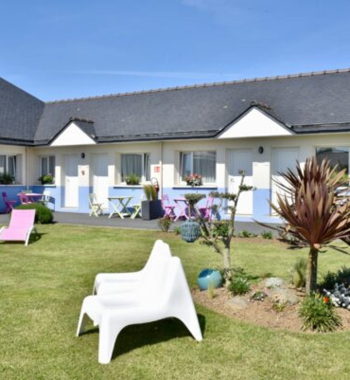 Jardin de l’Hôtel Heod à Binic- Étables-sur-Mer avec chaises et pelouse verdoyante