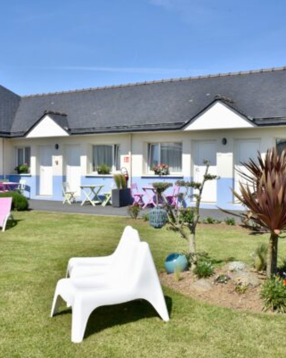 Jardin de l’Hôtel Heod à Binic- Étables-sur-Mer avec chaises et pelouse verdoyante